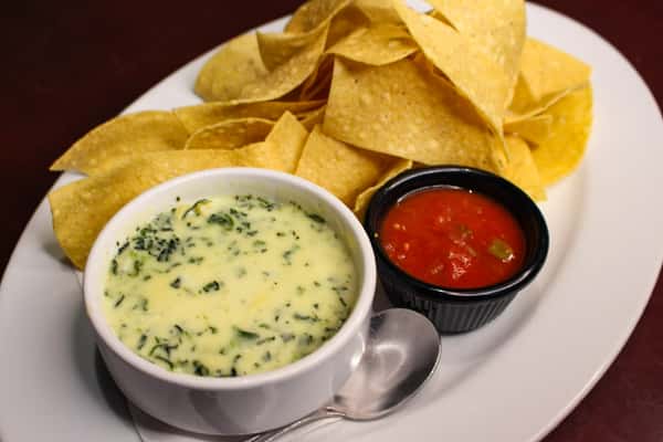 Tortilla chips served with spinach dip and salsa