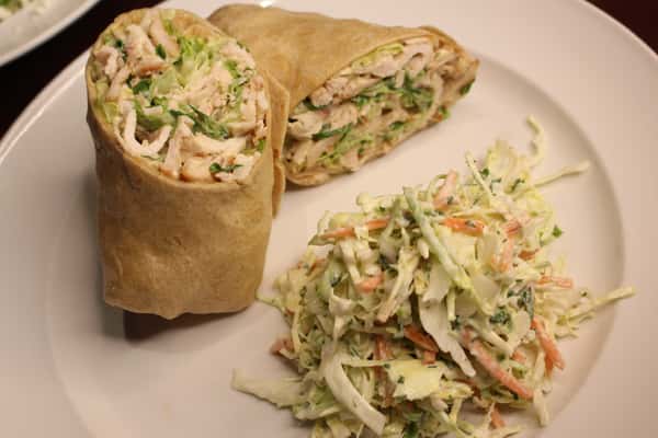 Chicken wrap cut in half, served with coleslaw