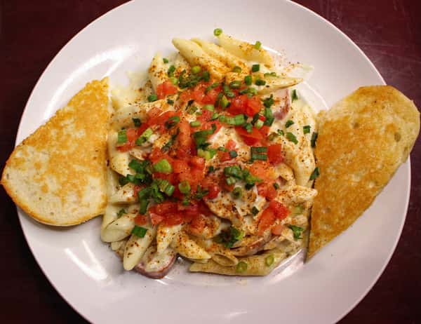 Crab cake served over seasoned rice with diced peppers, accompanied by cornbread