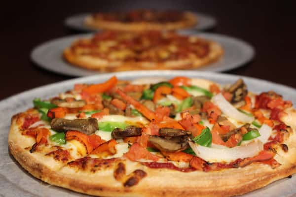 Pizza topped with pepperoni, tomato sauce, and fresh basil