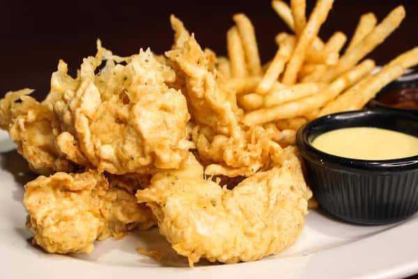 Fried seafood appetizer served with french fries and a dipping sauce