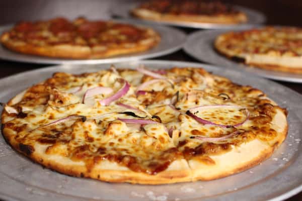 Flatbread pizza topped with red onions and greens
