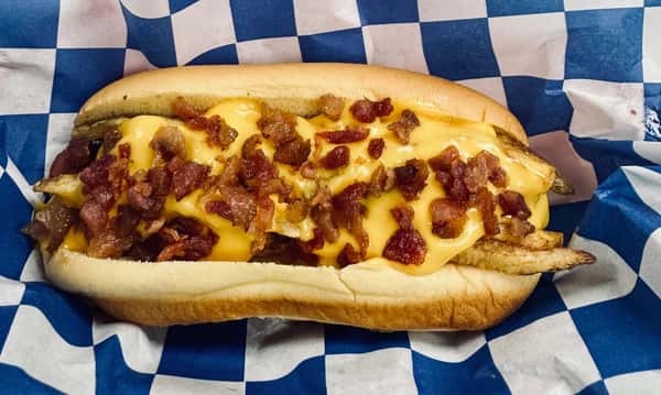 A char grilled dog topped with crispy French fries, cheese sauce, and bacon
