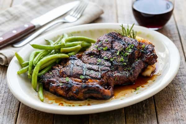 Saucy steak with seasoning and a side