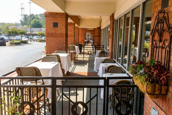 Exterior restaurant seating with warm sunshine and tables laid out