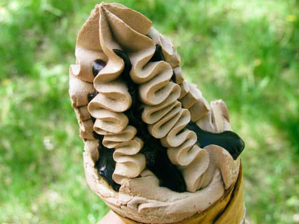 Chocolate soft serve ice cream in a waffle cone outdoors