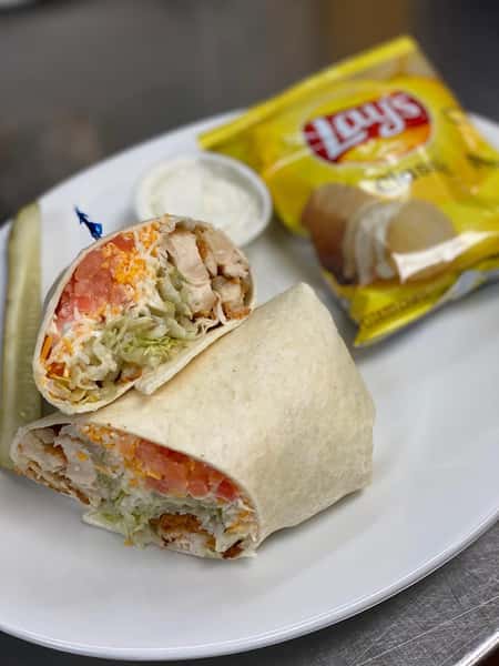 chicken wrap with tomatoes, lettuce, and cheese with a side of dipping sauce.
