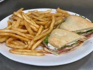 Ham, turkey, bacon, American and Swiss cheese, lettuce, tomato and mayo on white toast with a side of fries