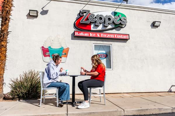 Two people eating Zeppe's Italian Ices outside