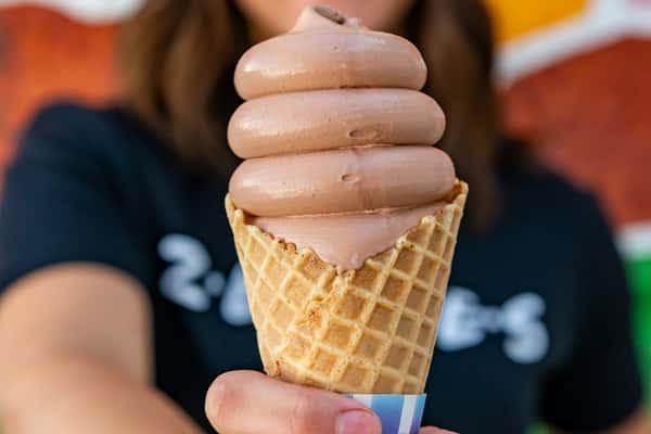 Person holding a waffle cone with frozen custard