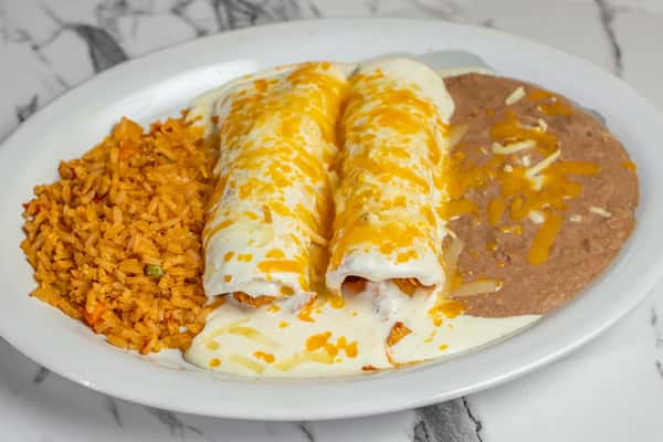 Two creamy chicken enchiladas topped with melted white cheese sauce, served with seasoned Mexican rice and refried beans.
