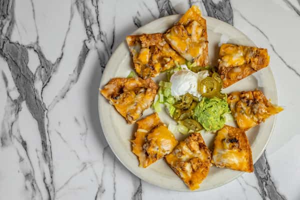 Crispy nacho triangles topped with melted cheese and seasoned meat, served with guacamole, sour cream, shredded lettuce, and jalapeños.