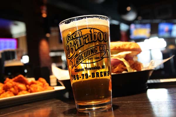 Great Baraboo branded beer glass filled with a lite beer with a burger in a basket in the background
