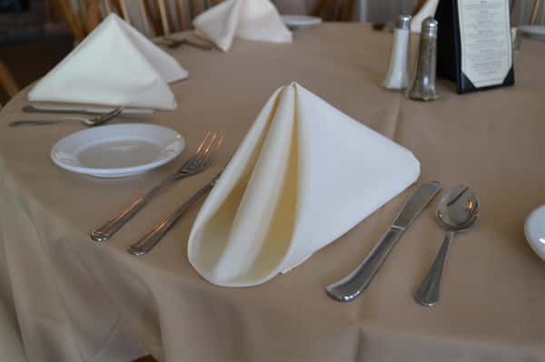 Neatly folded white napkin on a set table