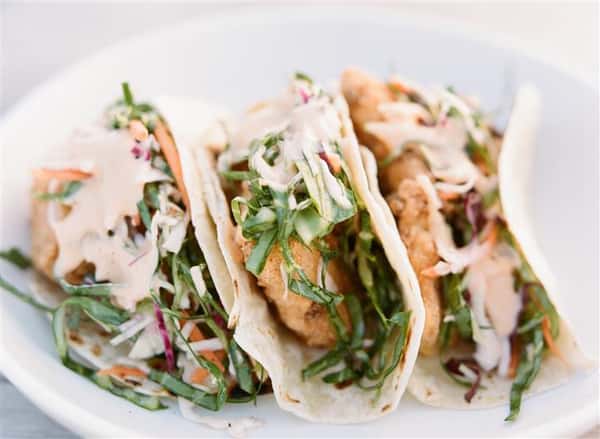 three chicken tacos with coleslaw