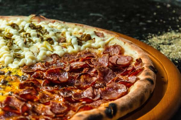 Specialty pizza topped with crispy pepperoni, sliced sausage, jalapeños, and a creamy cheese drizzle.