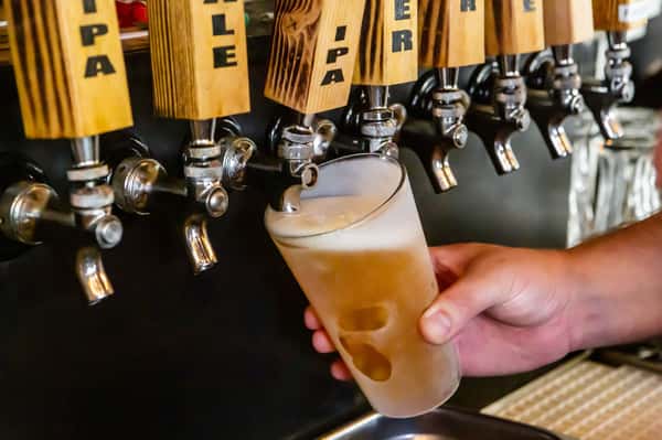 Backwoods Brewing tap handles with IPA pouring into pint glass.