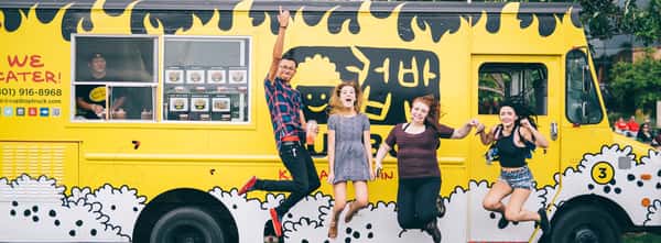 group jumping in front of the cup bop food truck