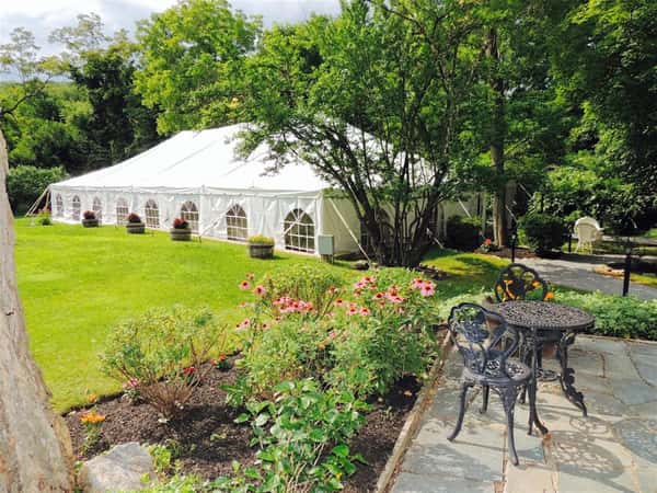 white tent on a lawn with flowers