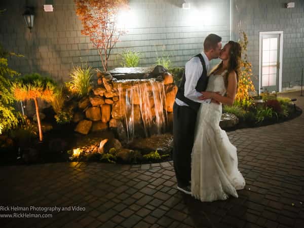 bride and groom kissing infront of waterfall