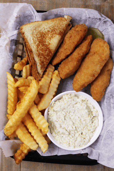 Hangry's Grill's basket of fried chicken tenders, fries, a grilled cheese sandwich, and coleslaw.