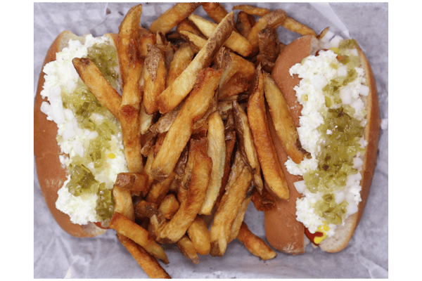 Hangry's Grill's two hot dogs topped with a creamy sauce and green relish, served with a generous pile of french fries.