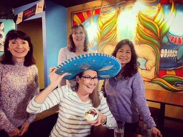 Group of women with one posing with a sombrero hat