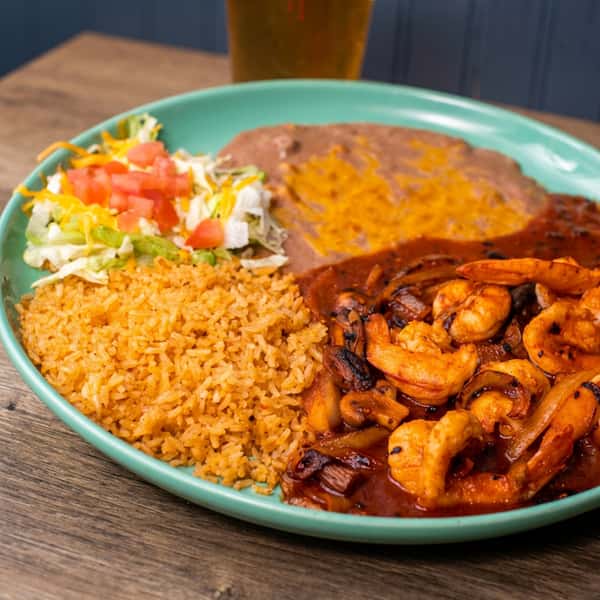 Shrimp fajita platter with rice, refried beans, and a side salad on a turquoise plate.