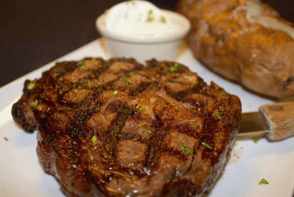 grilled rib eye with a baked potato with side of butter