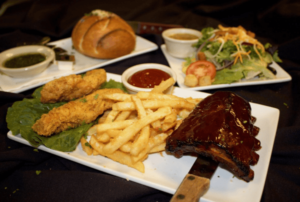 ribs with a side of fries and chicken fingers. Side salad with a side of dressing with bread and oil