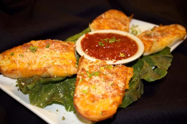 cheesy garlic bread with a side of dipping sauce