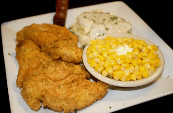 fried chicken with a side of mashed potatoes and corn