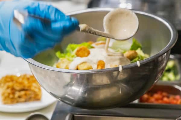 pouring dressing on salad