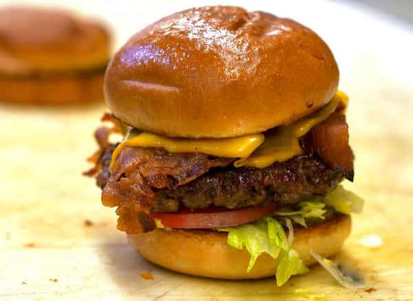 bacon cheeseburger with tomato, lettuce, and pickles