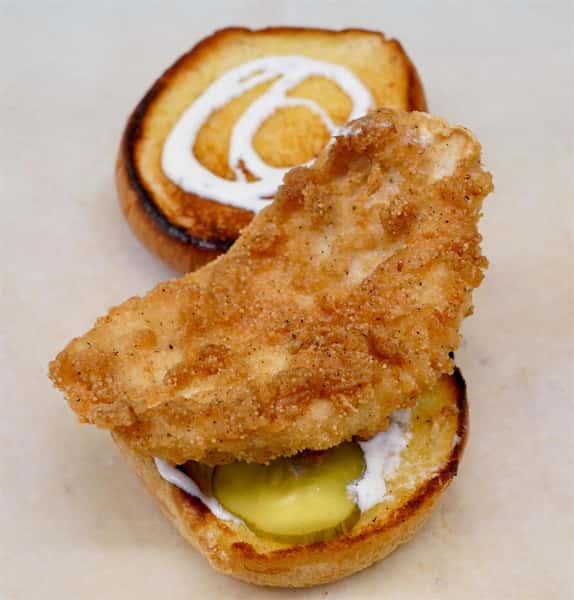 fried catfish sandwich with pickles and sauce