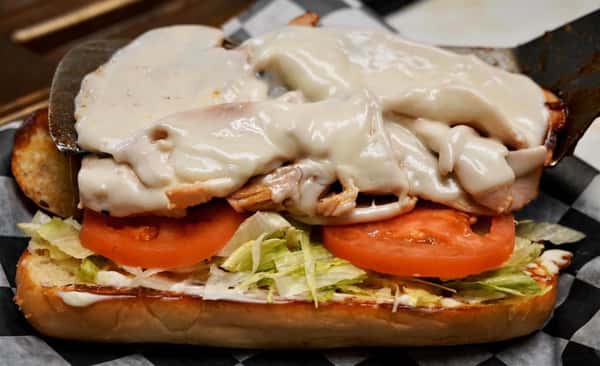 grilled chicken sandwich with dressing, tomatoes, and lettuce