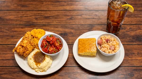 Fried chicken, mashed potatoes with gravy, stewed tomatoes, cornbread, white beans with sausage, and a Coca-Cola.