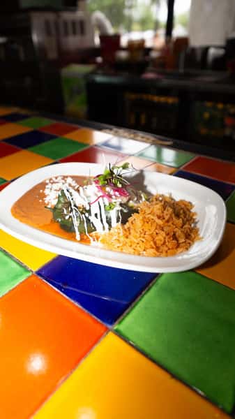 Milagro Tacos Cantina's vibrant chile relleno and rice dish served on a multi-colored tiled counter.