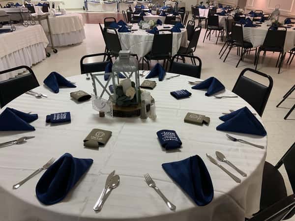 A round table set with napkins and silverware.