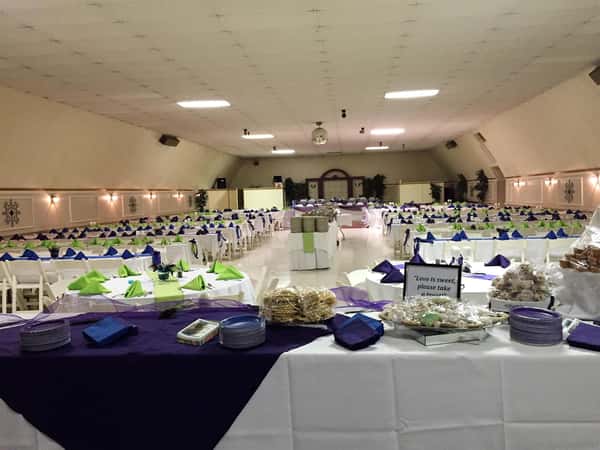 set of long tables setup with tablecloths, folded napkins and ribbon decorations