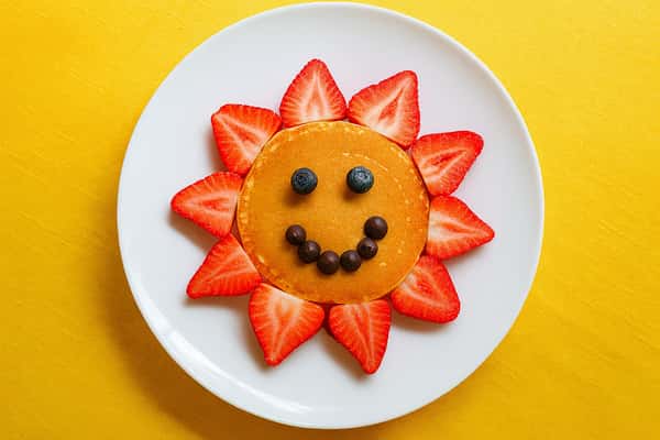 Pancake with blueberry smile and strawberries
