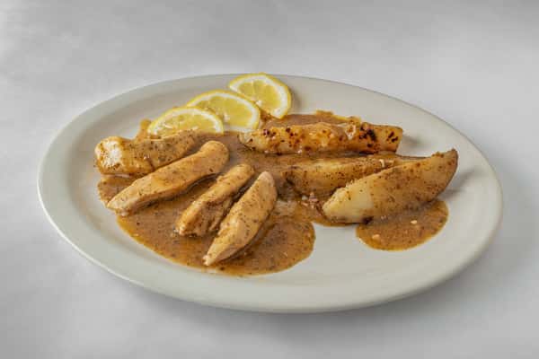 Grilled chicken breast tenders in a savory lemon pepper sauce, served with fresh lemon slices on a white plate — a light and zesty entrée.