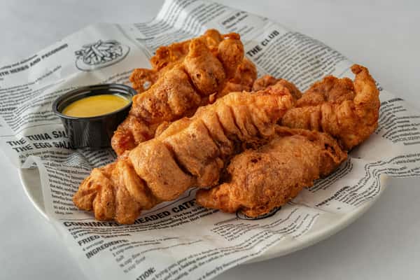 Crispy hand-breaded chicken tenders served on deli-style paper with a side of honey mustard dipping sauce — a comforting appetizer or kid-friendly meal.