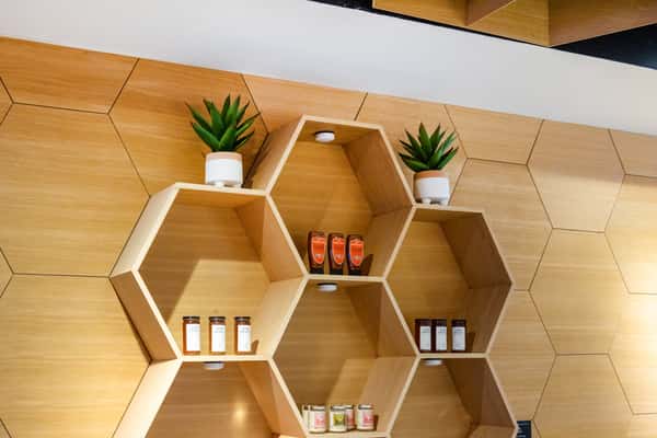 Modern café interior featuring custom honeycomb shelving, natural wood accents, and contemporary décor.