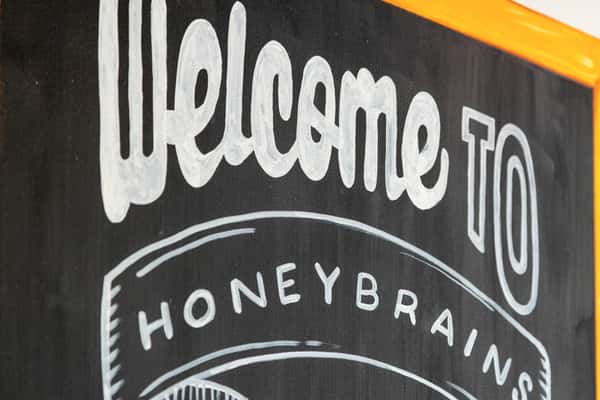 Close-up of café welcome signage highlighting the restaurant's friendly atmosphere and brand identity.