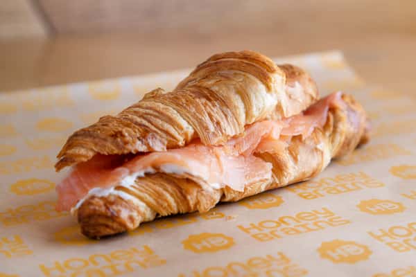 Buttery croissant sandwich filled with smoked salmon and fresh ingredients for a gourmet breakfast or brunch.
