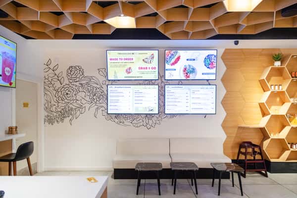 Contemporary café dining area with digital menu boards, modern seating, and a bright, inviting atmosphere.