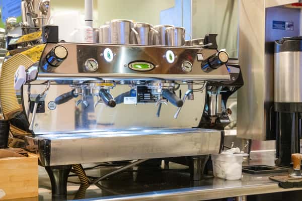 Professional espresso machine and coffee bar setup inside a modern café, serving specialty coffee and handcrafted beverages.