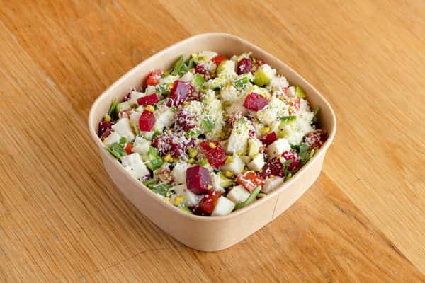 Fresh arugula salad with seasonal vegetables, grains, herbs, and vibrant ingredients for healthy dining.