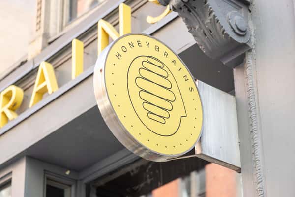 Exterior café storefront sign featuring modern branding and welcoming neighborhood coffee shop atmosphere.